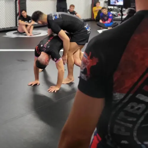 Scène d’un entraînement de grappling à Luxembourg où un athlète exécute une technique de transition debout. Ce type de lutte soumission met en avant la fluidité et la réactivité, essentielles dans le submission wrestling.